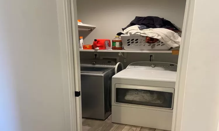 Laundry room featuring light wood-type flooring and separate washer and dryer