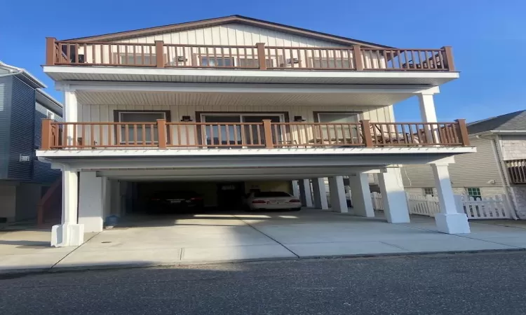 View of front of property with a balcony and a carport