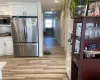 Kitchen featuring light hardwood / wood-style floors, appliances with stainless steel finishes, white cabinetry, and backsplash