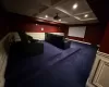 Carpeted cinema with beamed ceiling and coffered ceiling