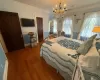 Bedroom featuring dark hardwood / wood-style flooring, a notable chandelier, and ornamental molding