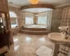 Bathroom featuring ornamental molding, independent shower and bath, and tile walls