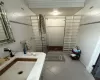 Bathroom with tile walls, tile patterned flooring, walk in shower, and sink