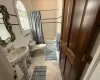 Bathroom featuring toilet, shower / bathtub combination with curtain, and tile walls