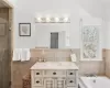 Full bath featuring vanity, tile walls, a bath, and a stall shower