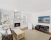 Living room featuring a tile fireplace, recessed lighting, a healthy amount of sunlight, and wood finished floors