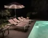 Patio at night featuring an outdoor pool