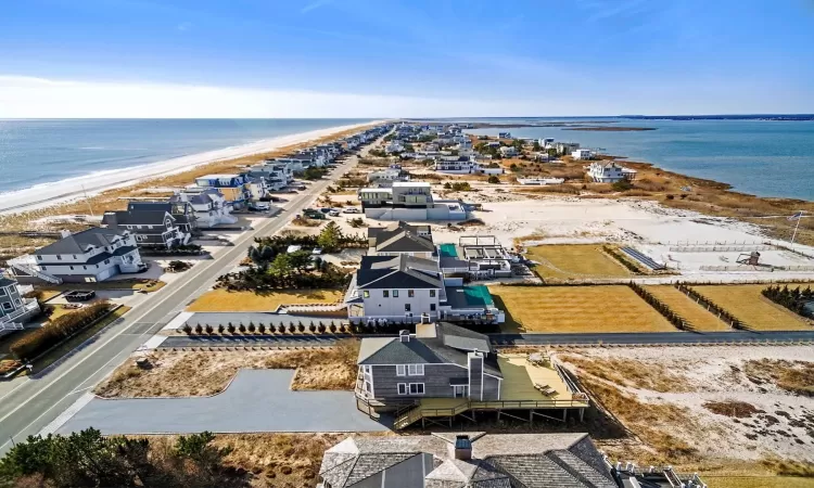 Birds eye view of property featuring a water view and a beach view