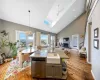 Kitchen with open floor plan, hanging light fixtures, a kitchen island with sink, a fireplace, and stainless steel dishwasher