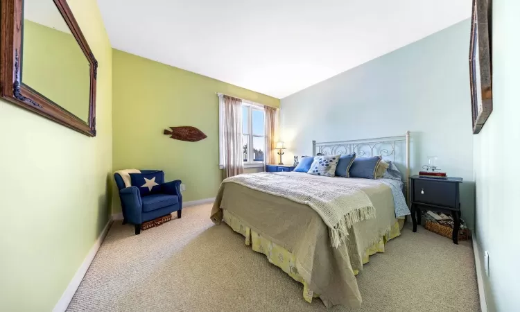 Bedroom featuring light carpet and baseboards