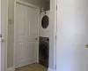 Laundry area with stacked washer / dryer, laundry area, and light tile patterned floors