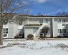 Snow covered rear of property with a garage