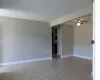 Unfurnished room featuring ceiling fan, light tile patterned floors, and baseboards