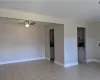 Empty room with light tile patterned floors, ceiling fan, and baseboards