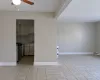 Kitchen featuring light tile patterned floors, ceiling fan, stainless steel stove, and baseboards