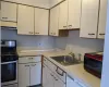 Kitchen with white cabinets, light countertops, a sink, and stainless steel gas range oven