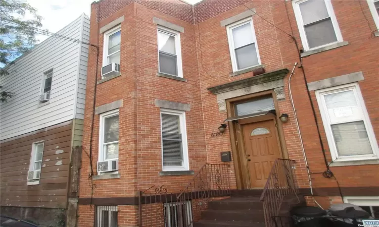 View of exterior entry featuring brick siding and cooling unit