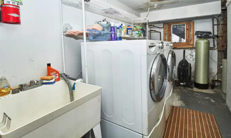 Laundry area featuring laundry area, a sink, and separate washer and dryer