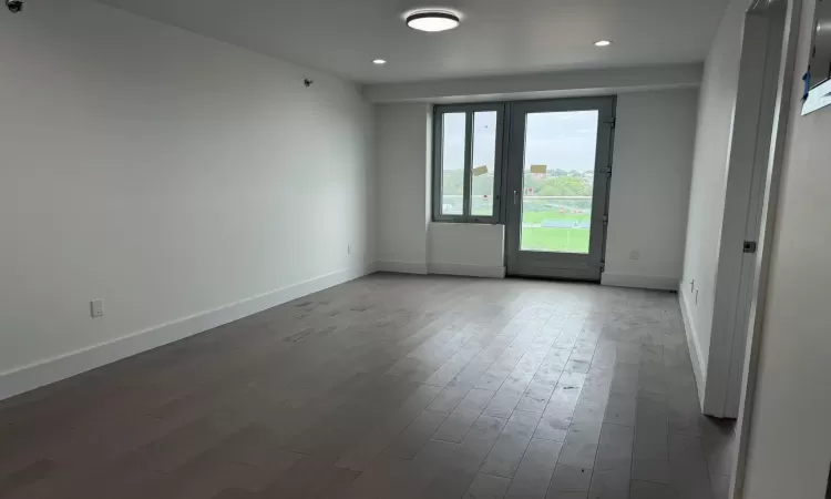 Unfurnished room featuring recessed lighting, wood finished floors, and baseboards