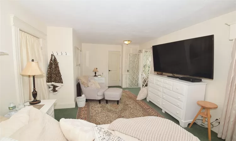 Bedroom with dark carpet and baseboards