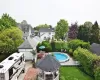 View of swimming pool featuring an outbuilding, a lawn, a gazebo, a residential view, and a fenced backyard