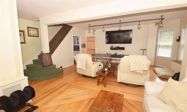 Living area featuring wood finished floors, baseboards, and stairs