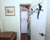 Laundry room featuring dark wood-style floors, stacked washer and dryer, and laundry area