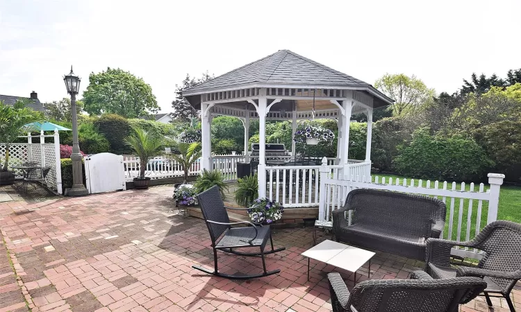 View of patio with a gazebo and fence