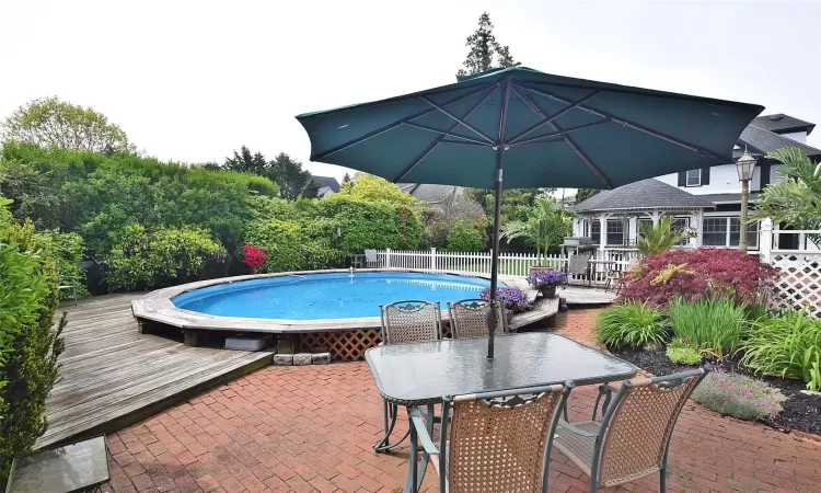 View of pool with outdoor dining space, fence, a wooden deck, and a fenced in pool