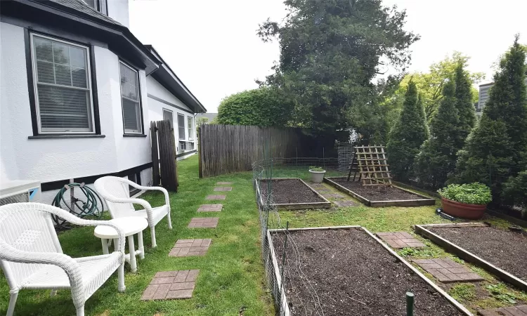 View of yard with a vegetable garden and fence