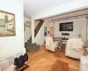 Living area featuring baseboards, radiator heating unit, parquet floors, rail lighting, and stairs