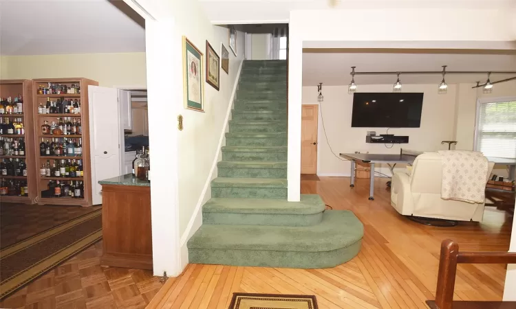 Stairway with parquet flooring, visible vents, and baseboards