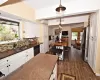 Kitchen with white cabinets, appliances with stainless steel finishes, backsplash, dark wood-style floors, and decorative light fixtures