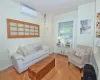 Living room featuring parquet flooring, baseboards, and a wall mounted AC