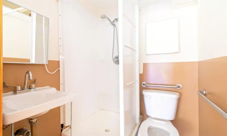 Full bathroom with a stall shower, a sink, and toilet