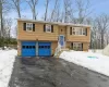 Split foyer home with driveway, a garage, and entry steps