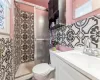 Bathroom featuring vanity, toilet, and a shower stall