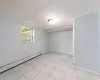 Spare room featuring baseboards, baseboard heating, and light tile patterned flooring