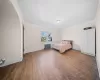 Unfurnished bedroom with dark hardwood / wood-style floors and radiator heating unit