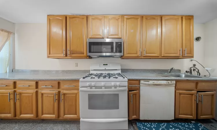 Kitchen with white appliances and sink