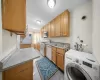 Kitchen with white appliances, sink, washer / clothes dryer, and light stone countertops