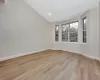 Unfurnished room featuring light hardwood / wood-style floors and lofted ceiling