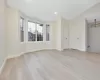 Unfurnished room with vaulted ceiling, light wood-type flooring, and an inviting chandelier