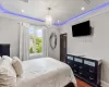 Bedroom with crown molding, dark wood-style flooring, a raised ceiling, and recessed lighting