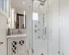 Full bathroom with vanity, a shower stall, tile walls, and decorative backsplash