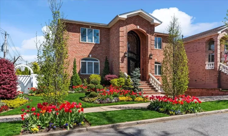 View of front of house with fence and brick siding