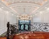 Corridor featuring an ornate ceiling, crown molding, a notable chandelier, a decorative wall, and vaulted ceiling