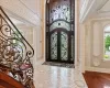 Foyer entrance featuring tile patterned flooring, a high ceiling, baseboards, french doors, and stairway