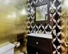 Bathroom featuring tile walls, vanity, and toilet