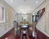 Dining space with an inviting chandelier, stairway, wood finished floors, and ornamental molding